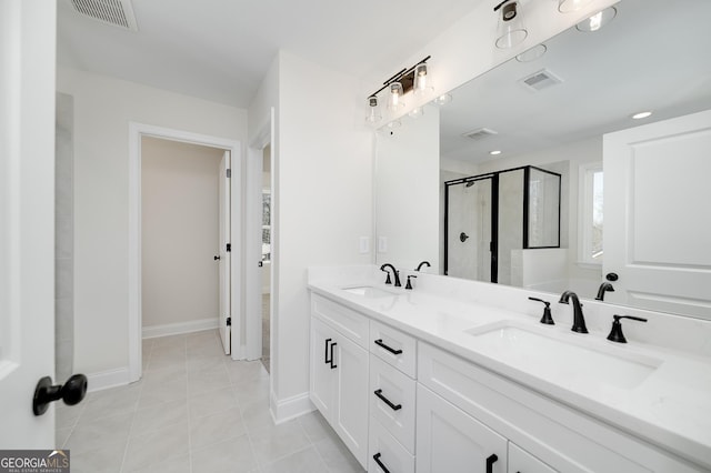 bathroom featuring tile patterned floors, a shower with door, and vanity