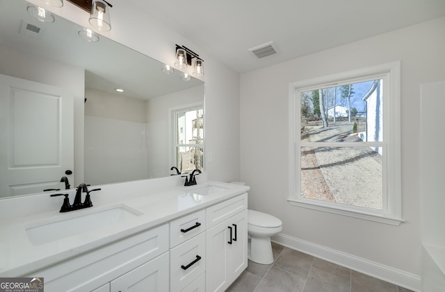 bathroom featuring toilet, vanity, and tile patterned flooring