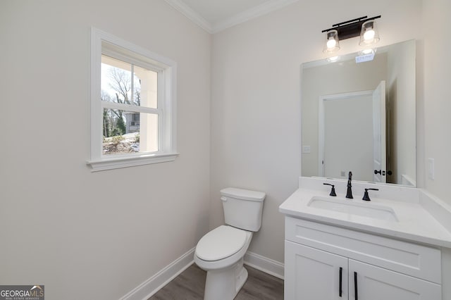 bathroom with toilet, ornamental molding, wood-type flooring, and vanity