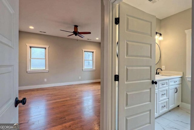 bathroom featuring wood-type flooring, ceiling fan, and vanity