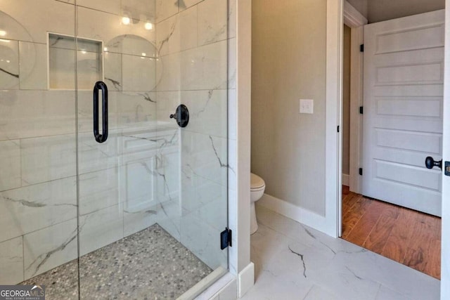 bathroom with a shower with shower door, hardwood / wood-style floors, and toilet