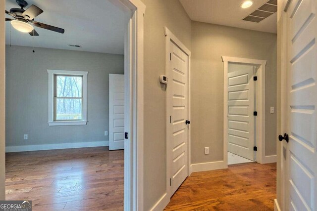 unfurnished room with light hardwood / wood-style floors, a wealth of natural light, and ceiling fan