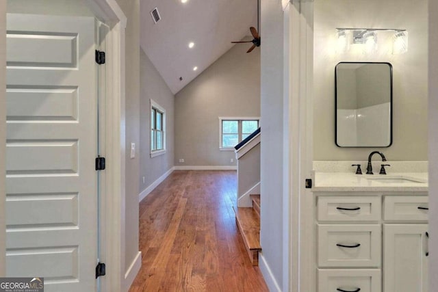 bathroom featuring ceiling fan, hardwood / wood-style floors, vanity, and lofted ceiling