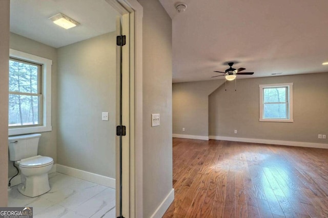 bonus room with a healthy amount of sunlight, ceiling fan, and light hardwood / wood-style floors