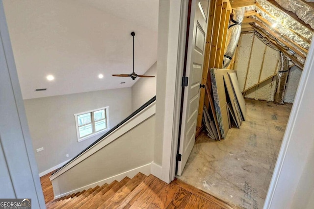 stairs with ceiling fan and vaulted ceiling