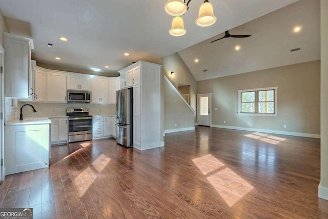 kitchen featuring appliances with stainless steel finishes, dark hardwood / wood-style floors, tasteful backsplash, and white cabinets