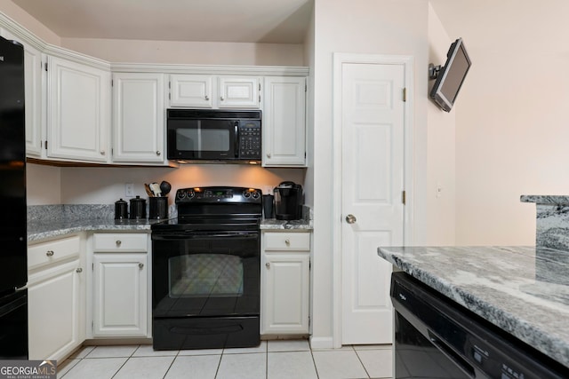 kitchen with black appliances, white cabinetry, light stone counters, and light tile patterned floors