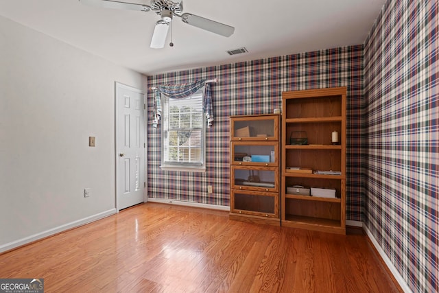 empty room featuring wood-type flooring and ceiling fan