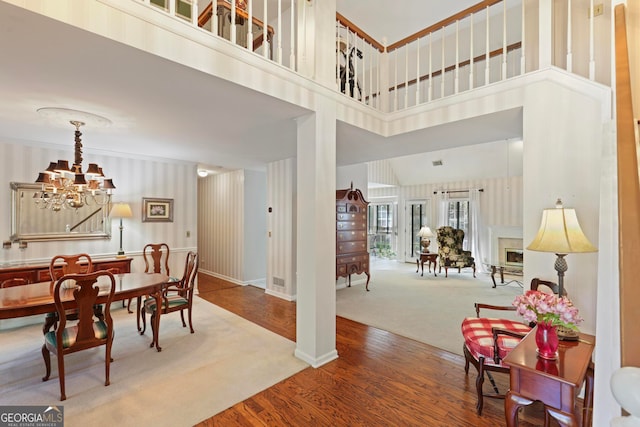 dining room featuring a high ceiling, a notable chandelier, and hardwood / wood-style flooring