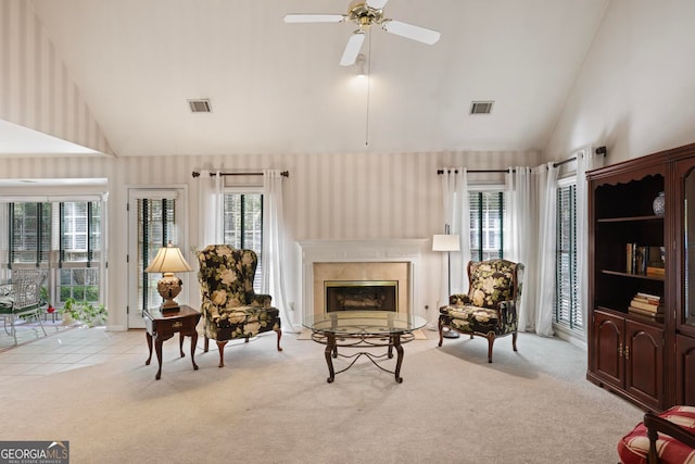 living area with light carpet, high vaulted ceiling, and ceiling fan