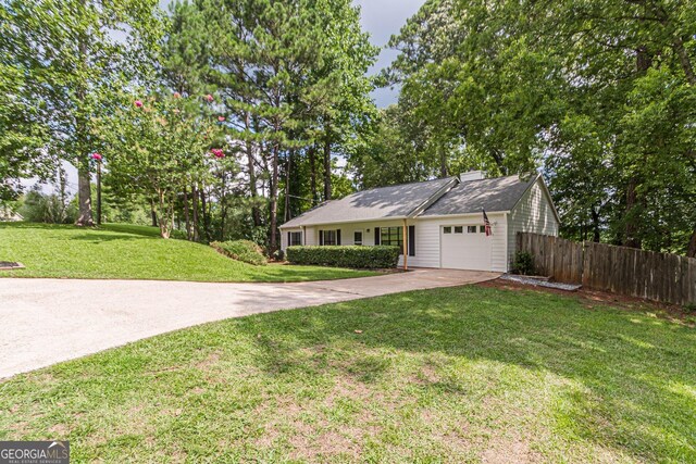 ranch-style home featuring a garage and a front lawn