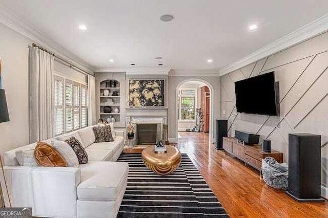 living room with a healthy amount of sunlight, wood-type flooring, and crown molding