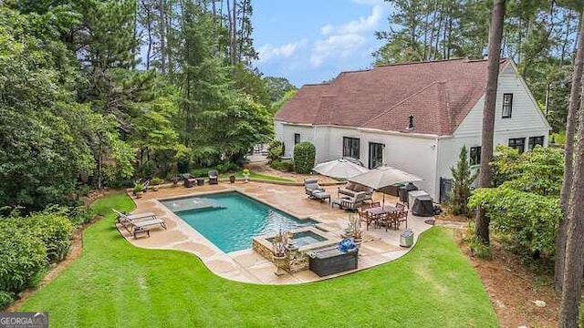 view of pool with a lawn, a patio area, and an in ground hot tub