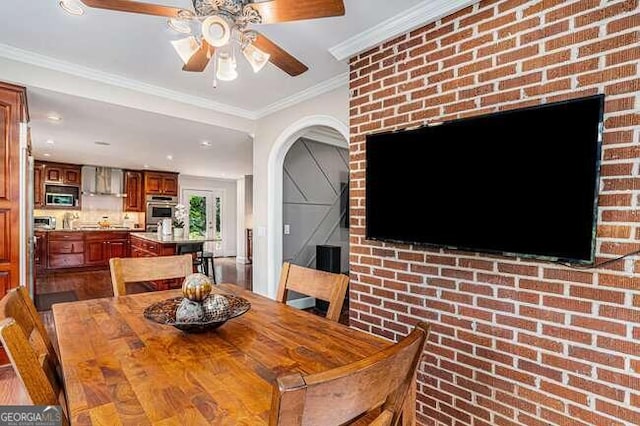 dining room featuring crown molding and brick wall