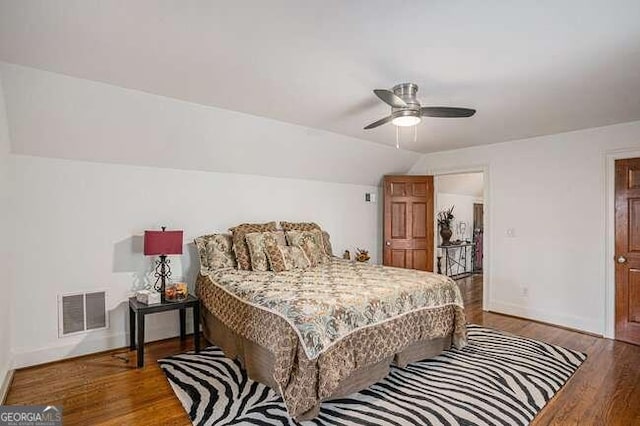 bedroom with ceiling fan, wood-type flooring, and lofted ceiling