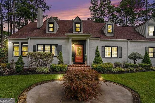 new england style home featuring a yard