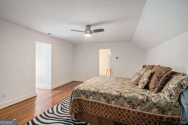 bedroom with hardwood / wood-style floors, ceiling fan, and vaulted ceiling