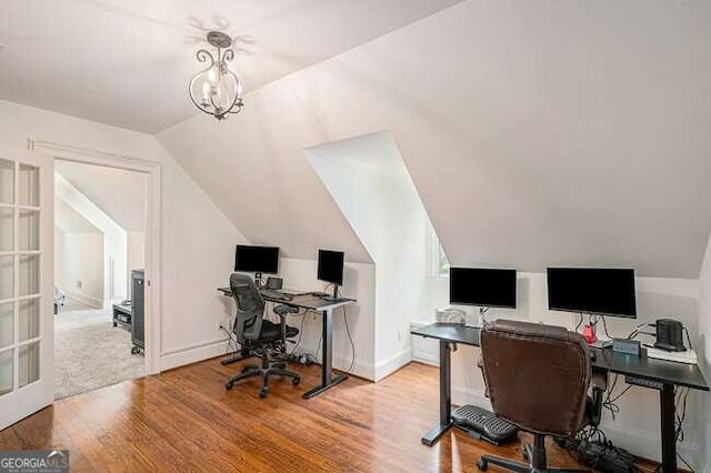 office featuring hardwood / wood-style flooring, a chandelier, and vaulted ceiling