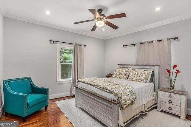 bedroom with ceiling fan, crown molding, and hardwood / wood-style flooring