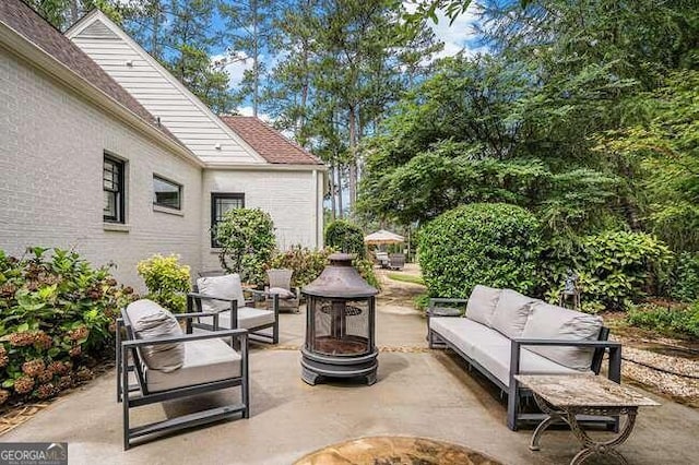 view of patio featuring an outdoor living space with a fire pit