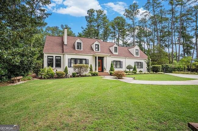 cape cod-style house with a front yard