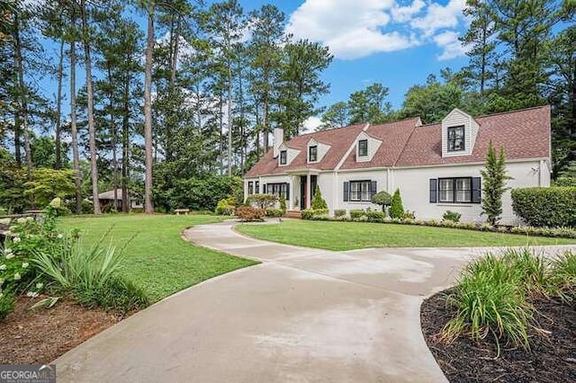 cape cod-style house with a front lawn