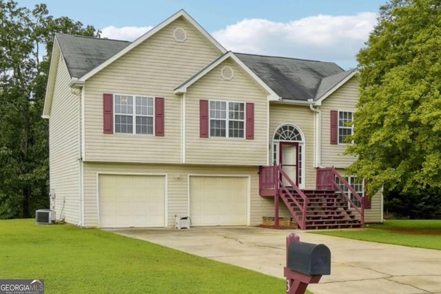 bi-level home featuring a garage, central AC, driveway, and a front lawn