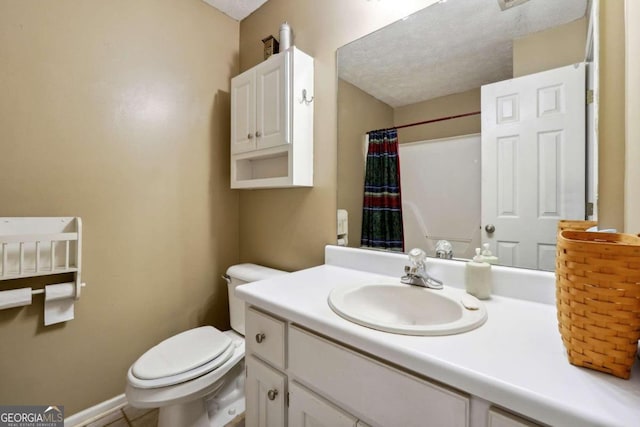 bathroom with baseboards, vanity, toilet, and a textured ceiling