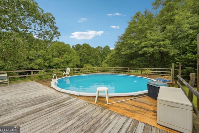 view of swimming pool with a wooden deck and a fenced in pool