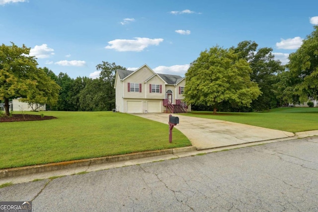 bi-level home featuring a garage, driveway, and a front lawn