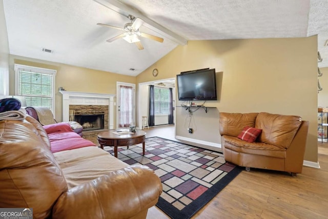 living room featuring visible vents, lofted ceiling with beams, ceiling fan, wood finished floors, and a textured ceiling