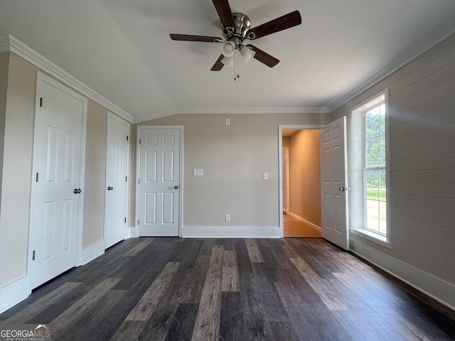 unfurnished bedroom with crown molding, vaulted ceiling, dark wood-type flooring, and ceiling fan