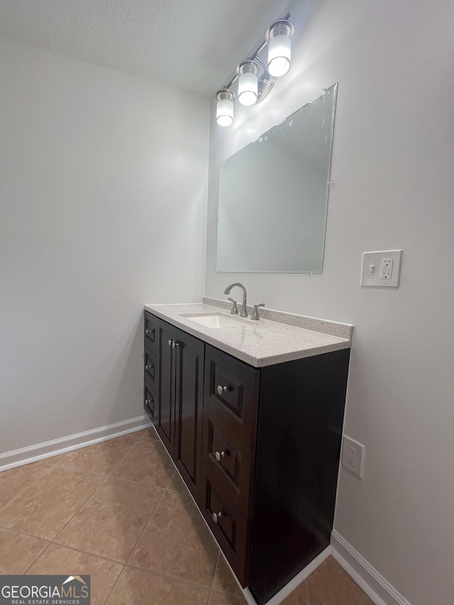 bathroom with tile patterned flooring, vanity, and a textured ceiling