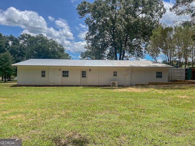 rear view of property featuring a lawn