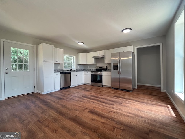 kitchen with appliances with stainless steel finishes, dark hardwood / wood-style floors, sink, and white cabinets