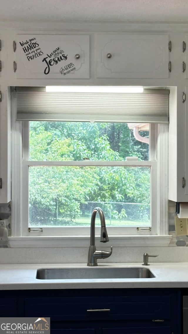 kitchen featuring a wealth of natural light, sink, and white cabinets