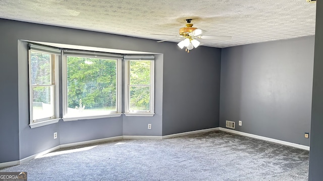 empty room with carpet flooring, ceiling fan, a textured ceiling, and a healthy amount of sunlight