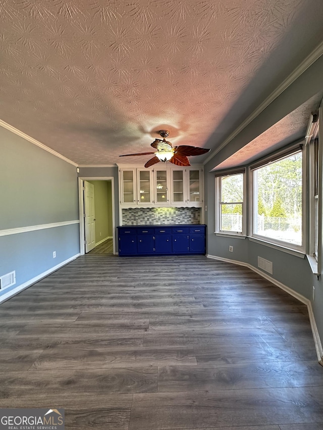 unfurnished living room featuring dark wood-style floors, visible vents, and crown molding