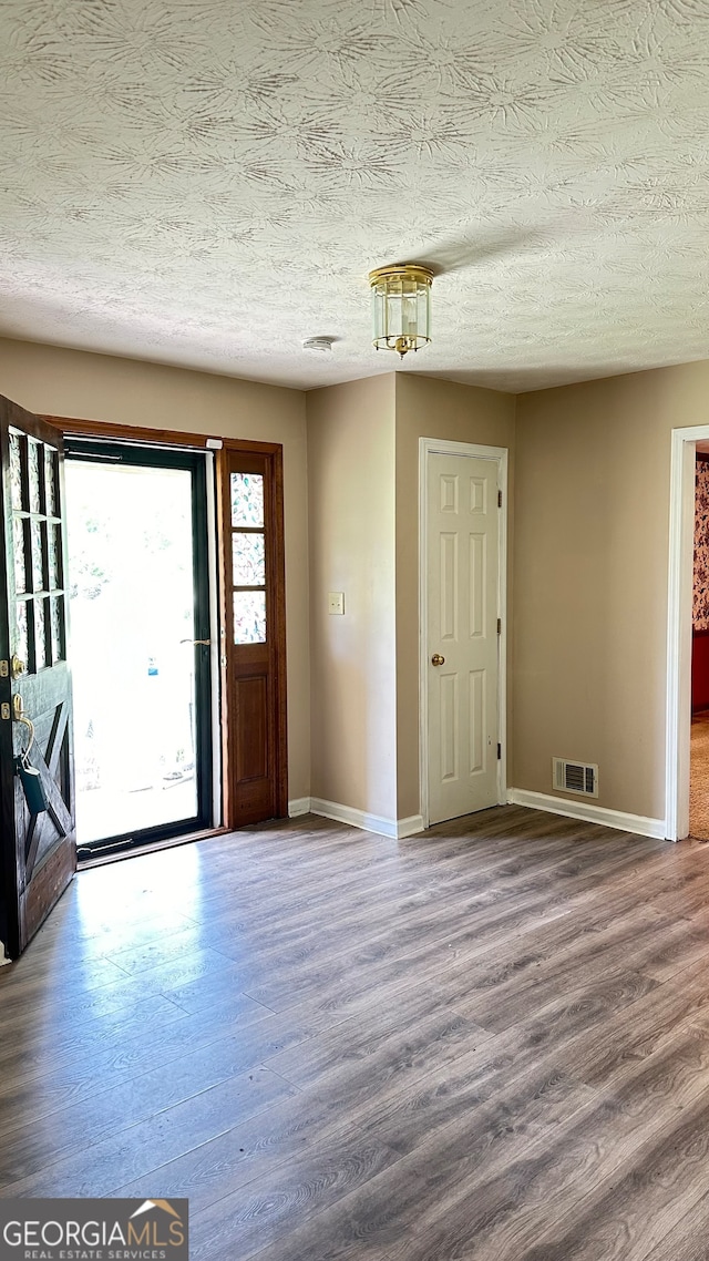 foyer with a textured ceiling and hardwood / wood-style floors