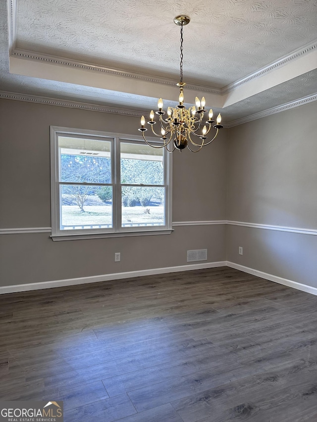 empty room with a tray ceiling, dark wood finished floors, visible vents, a textured ceiling, and baseboards