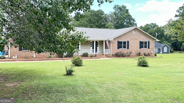 ranch-style home featuring covered porch, brick siding, and a front lawn