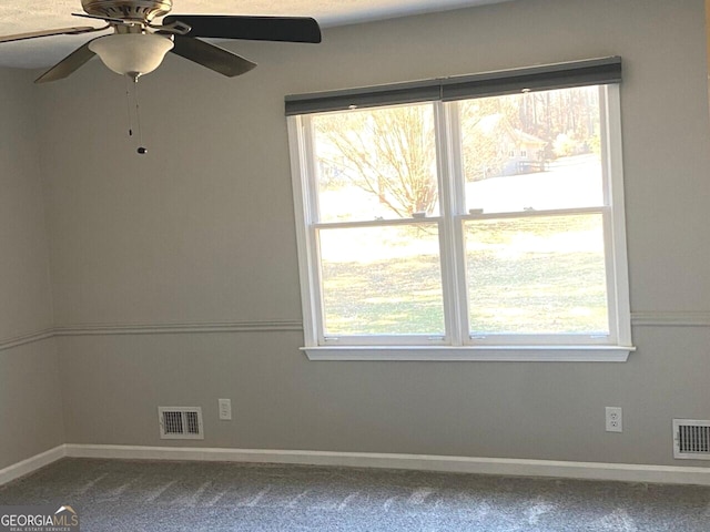 unfurnished room featuring plenty of natural light, visible vents, and baseboards