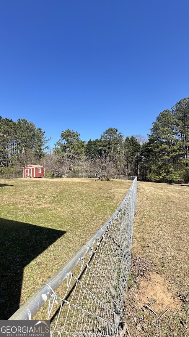 view of yard with fence and an outdoor structure