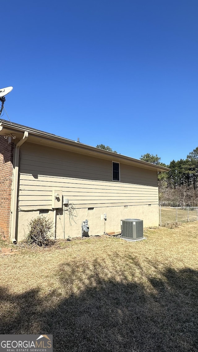 view of side of property featuring central AC and brick siding