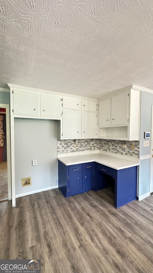 kitchen with blue cabinets, tasteful backsplash, white cabinets, and dark wood-type flooring