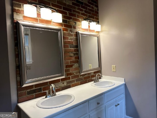 bathroom with vanity and brick wall