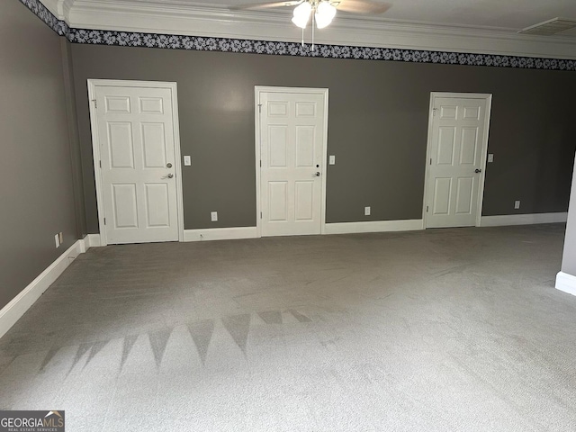 carpeted spare room with ceiling fan and ornamental molding