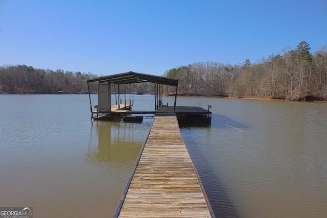 dock area with a water view and a view of trees