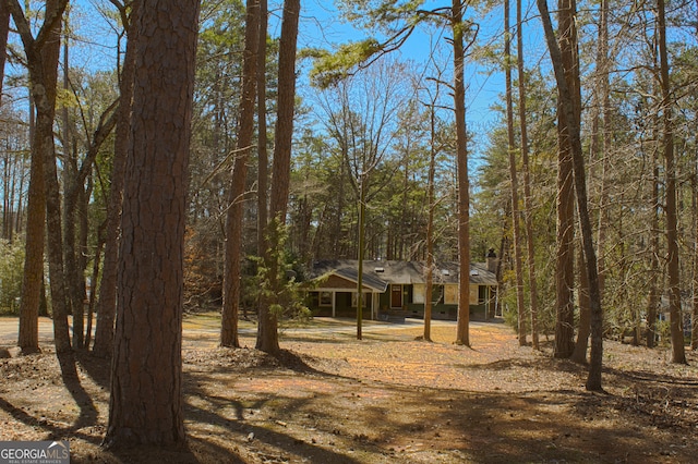 view of front of property with a forest view