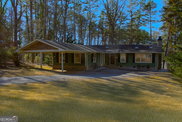 view of front of home featuring driveway, a chimney, and a front lawn